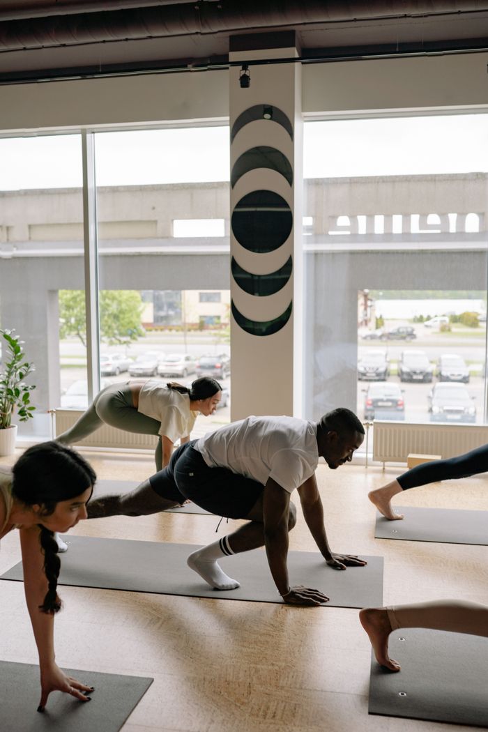 Crafting Captivating Headlines: Your awesome post title goes here A diverse group of adults practicing yoga poses indoors, promoting fitness and wellness.